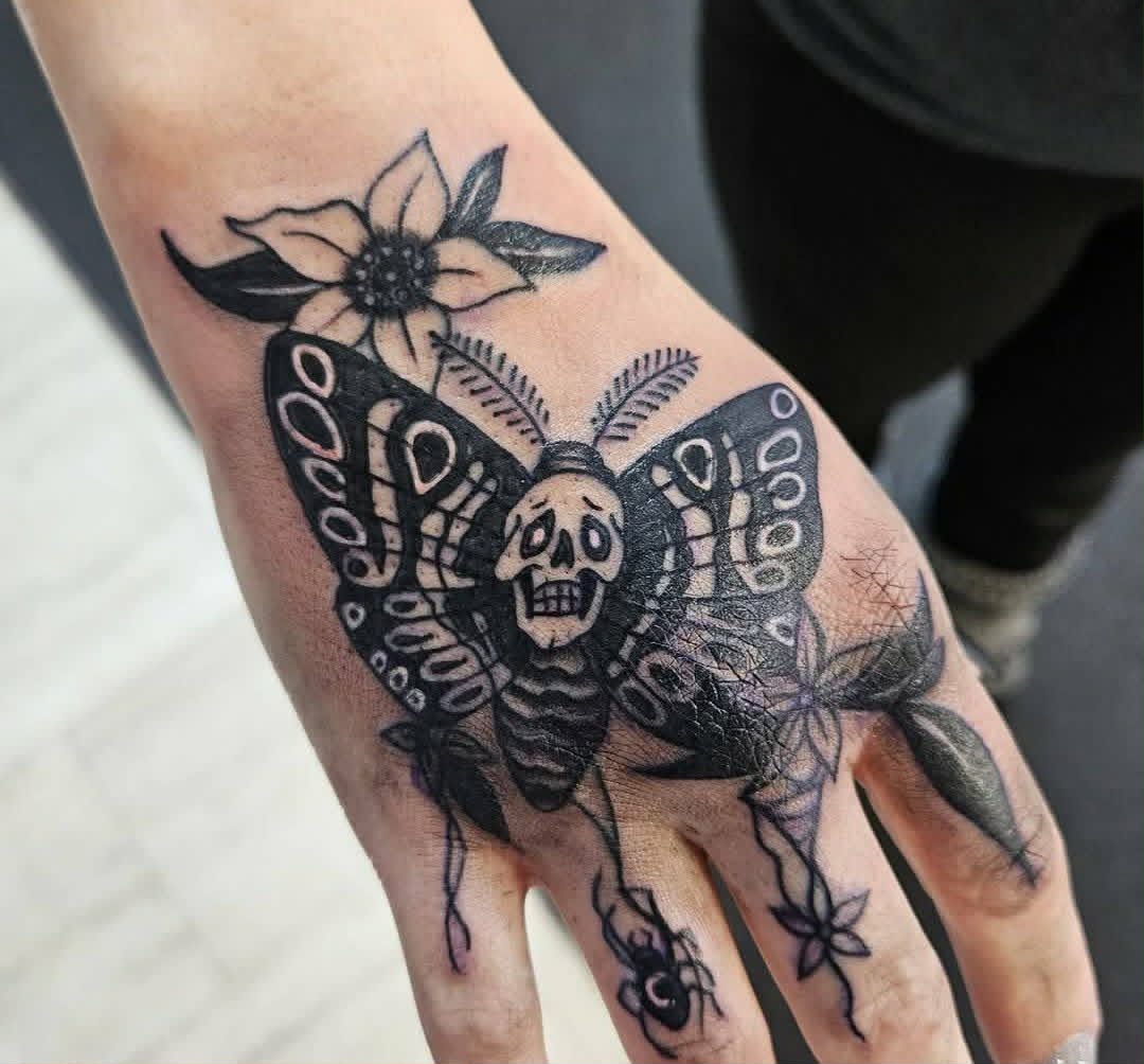 Blackwork skull moth hand tattoo
